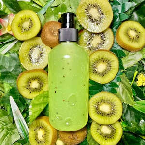 May include: A clear green bottle with a black pump top, surrounded by kiwi fruit slices on a bed of green leaves.