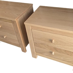 May include: Two wooden nightstands with two drawers each. The nightstands are made of light wood and have simple, modern designs.
