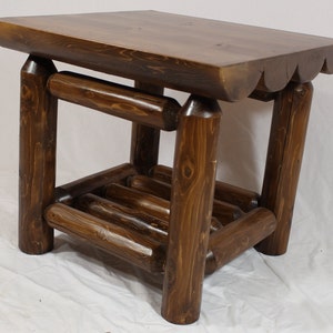 Könnte beinhalten: Ein dunkelbrauner Holz-Beistelltisch mit einem Regal. Der Tisch hat eine abgerundete Oberseite und ein rustikales Design.