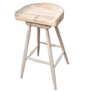 Puede incluir: Un taburete de bar de madera con un asiento ancho y curvo y cuatro patas. El taburete está hecho de madera de color claro y tiene un acabado natural.