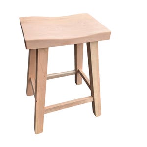 Puede incluir: Un taburete de madera de color claro con un asiento cuadrado y cuatro patas. El asiento tiene un diseño ligeramente curvado para mayor comodidad. El taburete está hecho de madera sin terminar, mostrando su veta y color naturales. Las patas están conectadas por un soporte horizontal.