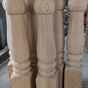 Puede incluir: Cinco patas de mesa de madera sin terminar con un diseño torneado. Las patas son de madera marrón claro y tienen una base cuadrada.