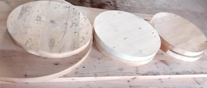 May include: Four unfinished wooden round platters of varying sizes. The platters are made of light-colored wood and have a smooth, polished surface.