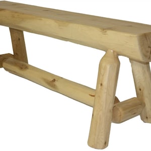 May include: A light-coloured wooden bench with a rectangular seat and angled legs. The bench is made from natural wood, showing the grain and knots. The legs are connected by a horizontal support beam.