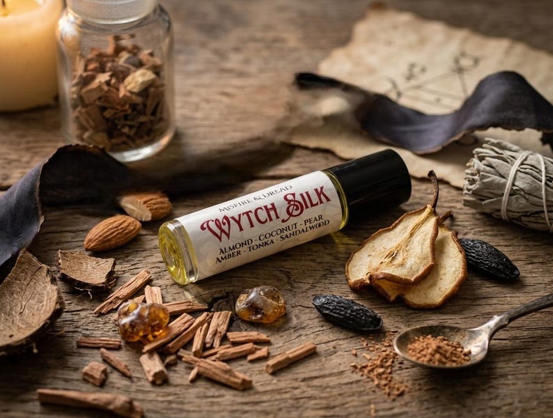 Puede incluir: Un frasco de perfume roll-on Wytch Silk con tapa negra y etiqueta blanca con texto rojo. Los ingredientes son almendras, coco, pera, &aacute;mbar, haba tonka y s&aacute;ndalo. El frasco est&aacute; rodeado de frutos secos, nueces y especias.