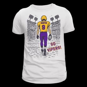 Pu&ograve; includere: Una t-shirt bianca con un'illustrazione grafica di un giocatore di football americano in maglia gialla con il nome MARTIN e il numero 9 in viola, pantaloni viola, che cammina su un campo da stadio con la scritta GO VIPERS! stampata in viola.