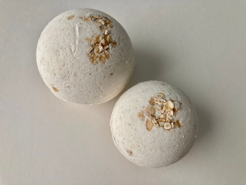Unscented Oatmeal Bath Bomb. The color is a natural light beige from the oatmeal mixed into the bath bomb. The Oatmeal bath bomb is also topped with whole grain oats. Dye free and fragrance free.  A Six and four ounce round bath bomb size, pictured.