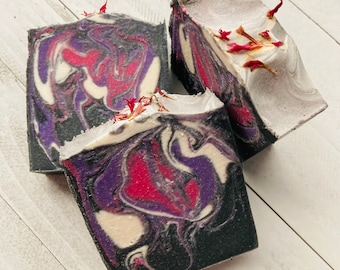 Jabón artesanal de leche de cabra con frambuesa negra y vainilla, elaborado con carbón activado.
