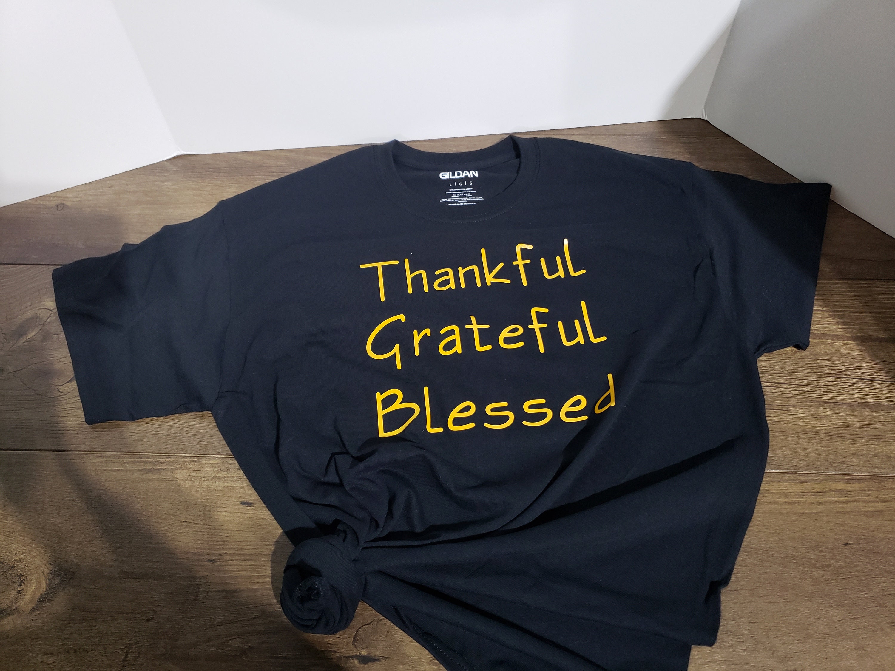 grey shirt with yellow writing