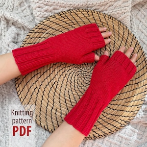 Könnte beinhalten: Ein Paar leuchtend rote Fingerhandschuhe, gestrickt mit gerippten Bündchen und einem strukturierten Muster auf dem Handrücken. Die Handschuhe werden auf einem gewebten, kreisförmigen Platzdeckchen präsentiert. Der Text auf dem Bild lautet "Knitting pattern PDF".