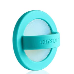 May include: A round, teal-colored product with a white, translucent center. The product has a teal band with the word "CRYSTALFY" printed on it. The product is circular and appears to be made of silicone or a similar material.