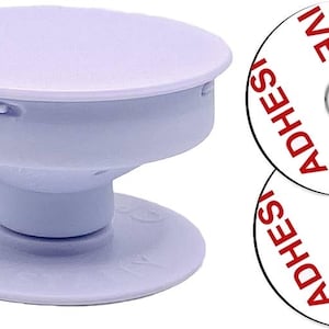 May include: A light lavender collapsible phone grip with a circular top and base, accompanied by two white circular adhesive pads featuring the red text ADHESIVE printed in a repeating pattern around the center hole of each pad.