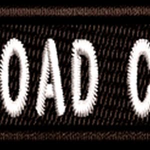 May include: Black embroidered patch with white text that reads "ASST. ROAD CAPTAIN".