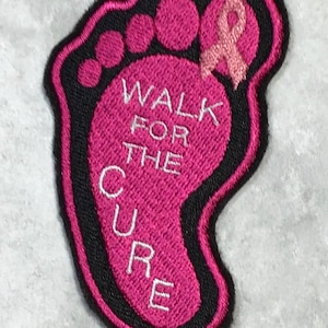 May include: Pink fabric foot print with a pink ribbon and the text "Walk for the Cure" in white.