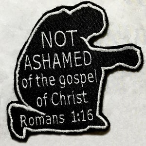 May include: Black embroidered patch with a kneeling figure and the text "NOT ASHAMED of the gospel of Christ Romans 1:16".