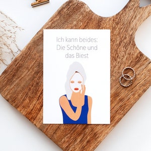 Könnte beinhalten: Eine weiße Karte mit einer Frau, die ein blaues Shirt und eine weiße Gesichtsmaske trägt. Der Text auf der Karte lautet "Ich kann beides: Die Schöne und das Biest."