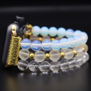 K&ouml;nnte beinhalten: Ein goldenes Armband mit drei Schichten Perlenarmb&auml;ndern. Die oberste Schicht ist hellblau, die mittlere Schicht ist wei&szlig; und die unterste Schicht ist klar.