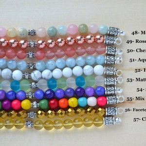 May include: Ten rows of colorful gemstone bracelets with silver clasps. The bracelets are arranged from top to bottom in the following order: Morganite, Rose Hematite, Cherry Quartz, Aquamarine, Howlite, Matte Mix Aqua, Sugilite, Mix Color Howlite, Faceted Gold Hematite, and Clear Citrine.