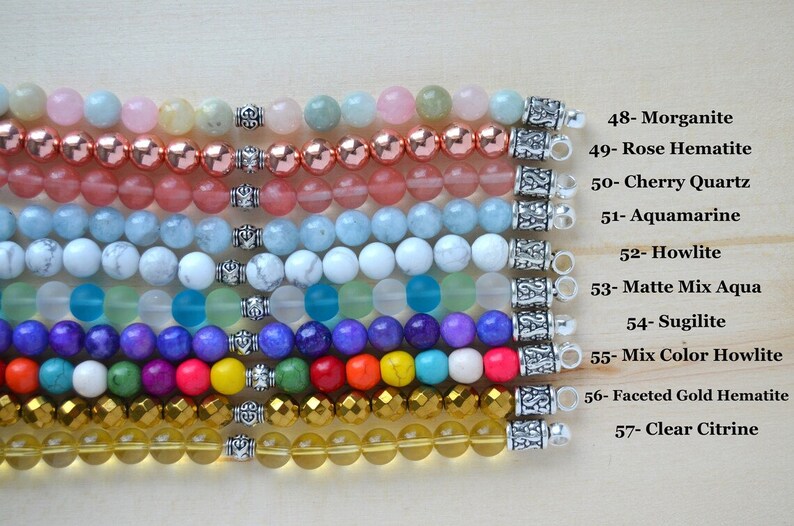May include: Ten rows of colorful gemstone bracelets with silver clasps. The bracelets are arranged from top to bottom in the following order: Morganite, Rose Hematite, Cherry Quartz, Aquamarine, Howlite, Matte Mix Aqua, Sugilite, Mix Color Howlite, Faceted Gold Hematite, and Clear Citrine.