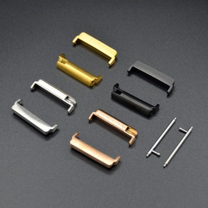 Puede incluir: Un conjunto de seis conectores de correa de reloj de metal en oro, plata, oro rosa y negro. Los conectores están diseñados para sujetar una correa de reloj a una caja de reloj.