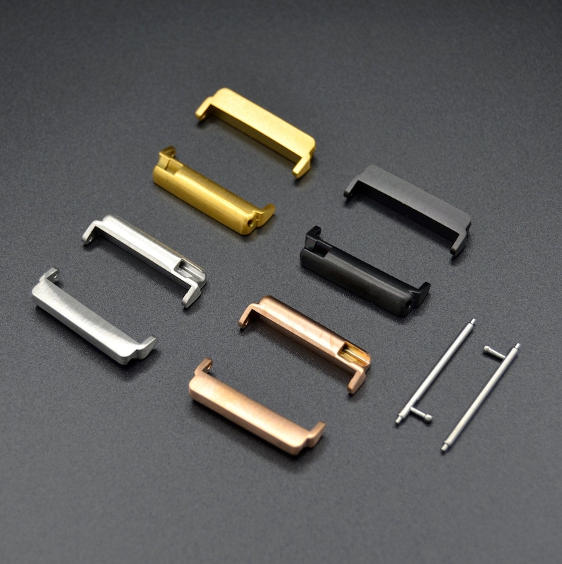 May include: A set of six metal watch band connectors in gold, silver, rose gold, and black. The connectors are designed to attach a watch band to a watch case.