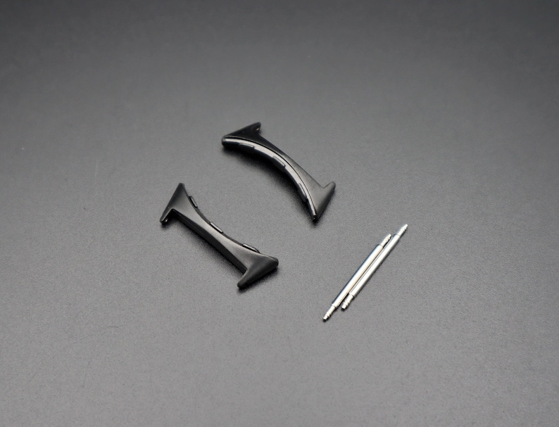 May include: Two black watch strap spring bars and three silver spring bars.