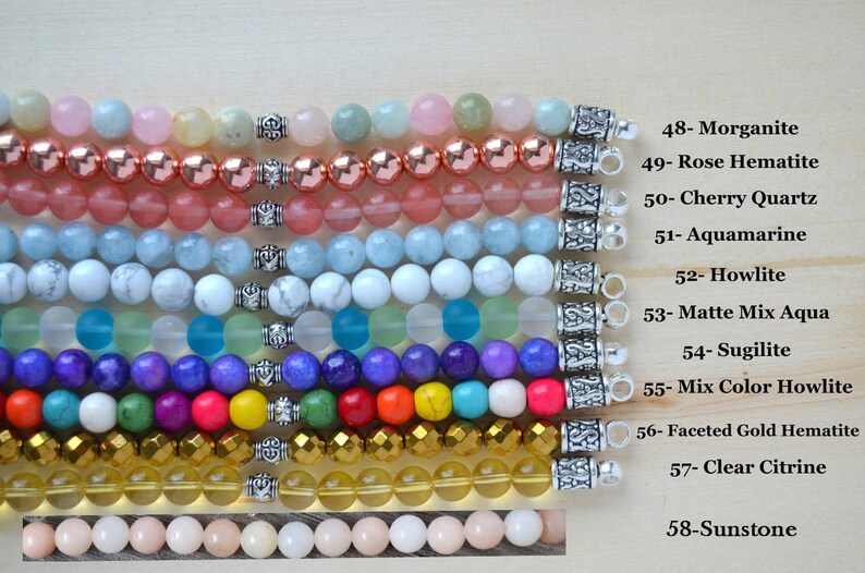 May include: Ten rows of colorful gemstone beads with silver clasps. The beads are arranged in rows from top to bottom, with each row representing a different type of gemstone. The gemstones include morganite, rose hematite, cherry quartz, aquamarine, howlite, matte mix aqua, sugilite, mix color howlite, faceted gold hematite, clear citrine, and sunstone.