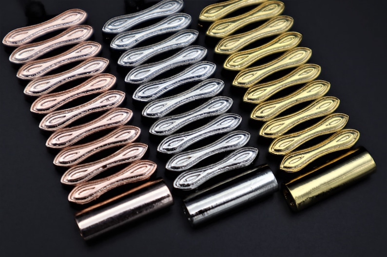 K&ouml;nnte beinhalten: Drei Metallarmb&auml;nder mit einem einzigartigen, ineinandergreifenden Design. Die Armb&auml;nder sind in Ros&eacute;gold, Silber und Gold.