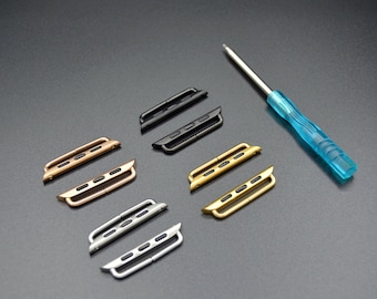 Könnte beinhalten: Sechs Metall-Uhrenbandadapter in verschiedenen Farben: Schwarz, Silber, Gold, Roségold. Die Adapter sind so konzipiert, dass sie ein Uhrenband an eine Uhr anschließen. Ein blauer Schraubendreher ist ebenfalls enthalten.