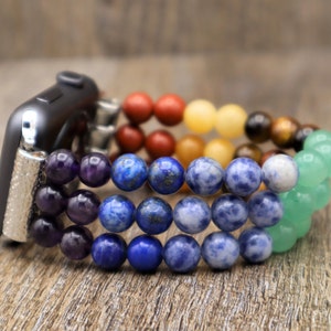 Op de afbeelding: Een regenboogkleurig kralenbandje voor de Apple Watch met amethist, lapis lazuli, sodaliet, tijgeroog, citrien, carneol en aventurijn kralen.