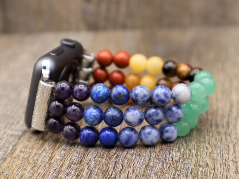 Op de afbeelding: Een regenboogkleurig kralenbandje voor de Apple Watch met amethist, lapis lazuli, sodaliet, tijgeroog, citrien, carneol en aventurijn kralen.