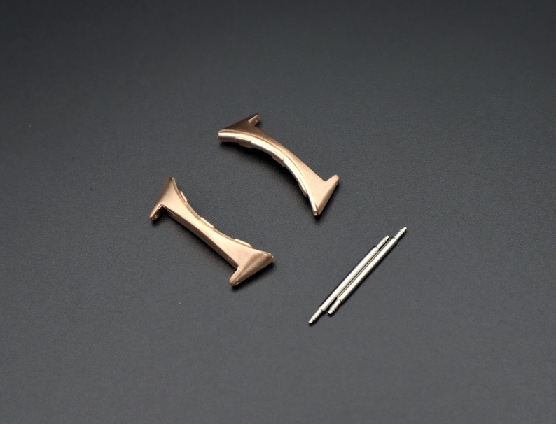 May include: Two gold-toned watch band spring bars and two gold-toned watch band end pieces.