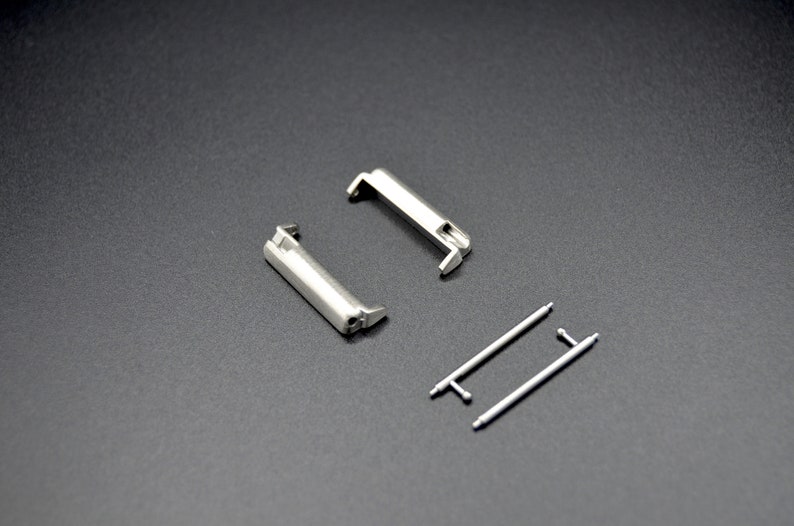 May include: Two silver watch band spring bars and two silver watch band quick release pins.