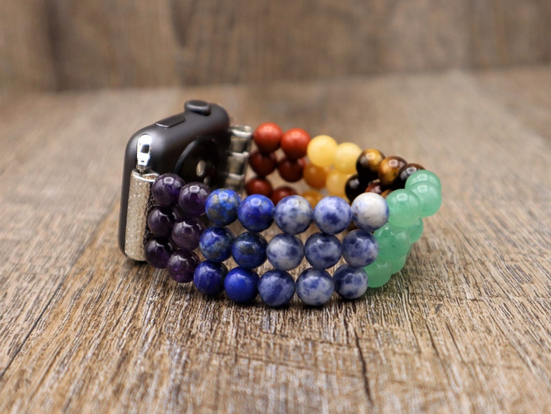 Op de afbeelding: Een regenboogkleurig kralen Apple Watch bandje gemaakt met amethist, lapis lazuli, sodaliet, aventurijn, citrien, tijgeroog en rode jaspis.
