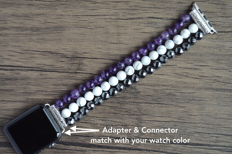 May include: A beaded Apple Watch band with amethyst, white howlite, and black hematite beads. The adapter and connector match the watch color.