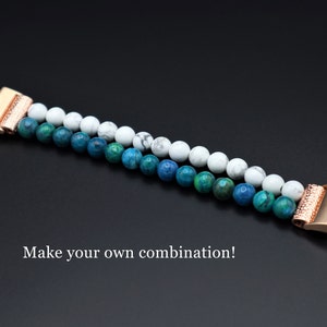 May include: A two-toned beaded bracelet with white and blue beads. The bracelet has a rose gold clasp and is made of natural stones. "Make your own combination!" is written below the bracelet.