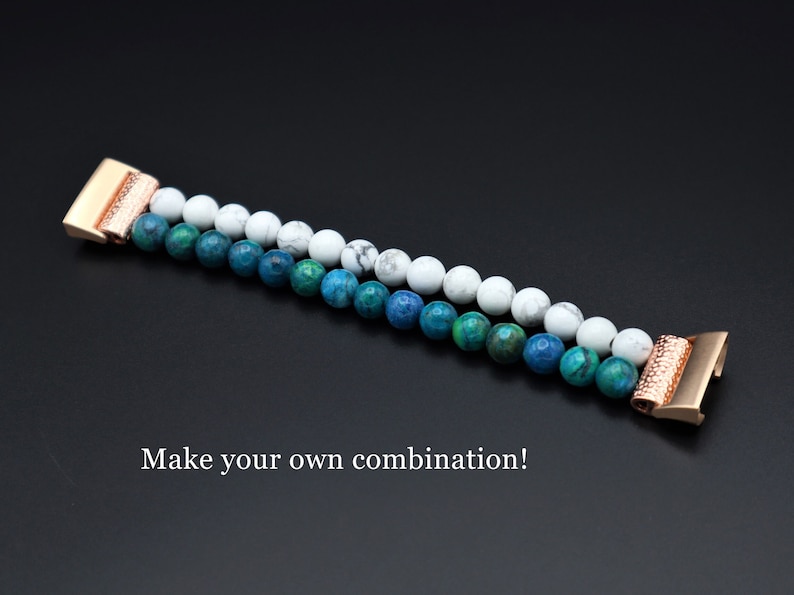 May include: A two-toned beaded bracelet with white and blue beads. The bracelet has a rose gold clasp and is made of natural stones. "Make your own combination!" is written below the bracelet.
