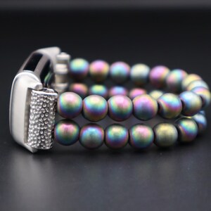 May include: A silver and iridescent beaded watch strap with a silver clasp.