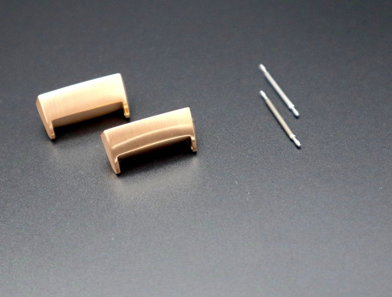 Puede incluir: Dos pasadores de resorte para correa de reloj de metal dorado y dos herramientas de pasador de resorte plateadas.
