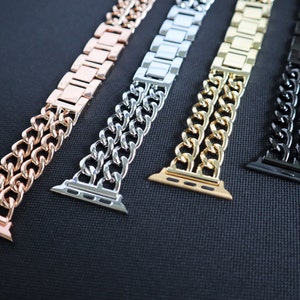 Puede incluir: Cuatro correas de Apple Watch de diferentes colores con un diseño de doble cadena. Las correas son de oro rosa, plata, oro y negro.