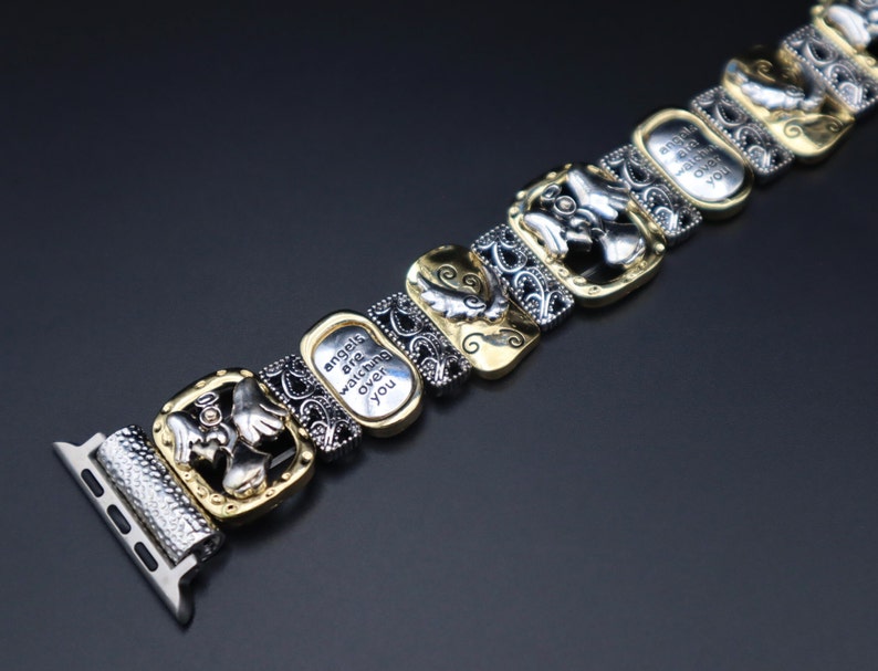 May include: A silver and gold watch band with an angel design and the inscription "angels are watching over you".