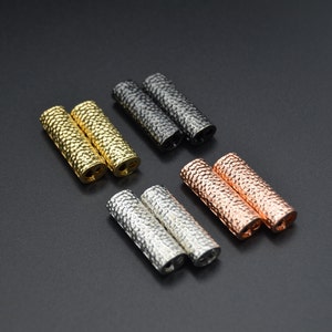 Puede incluir: Conjunto de seis terminales de cordón de metal en cuatro acabados diferentes: dorado, plateado, negro y oro rosa. Cada terminal está texturizado con un acabado martillado.
