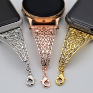 May include: Three Apple Watch bands with a decorative, ornate design. The bands are silver, rose gold, and gold. Each band has a clasp closure.