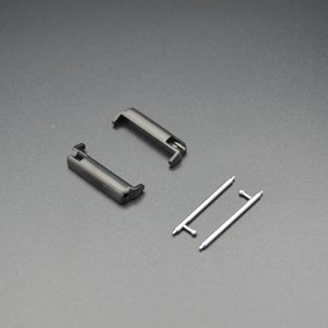 May include: Two black metal watch band spring bars and two silver metal watch band spring bars.