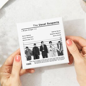 Peut inclure: Impression sur toile carr&eacute;e blanche avec le titre du film "The Usual Suspects" et une photo en noir et blanc des acteurs. L'impression comprend les noms des acteurs et l'ann&eacute;e 1995.