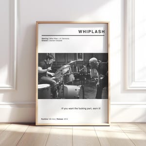 May include: A framed black and white movie poster for "Whiplash" with a wooden frame. The poster features a drummer and a man looking on. Text includes the movie title, credits, and the quote "/if you want the fucking part, earn it!"