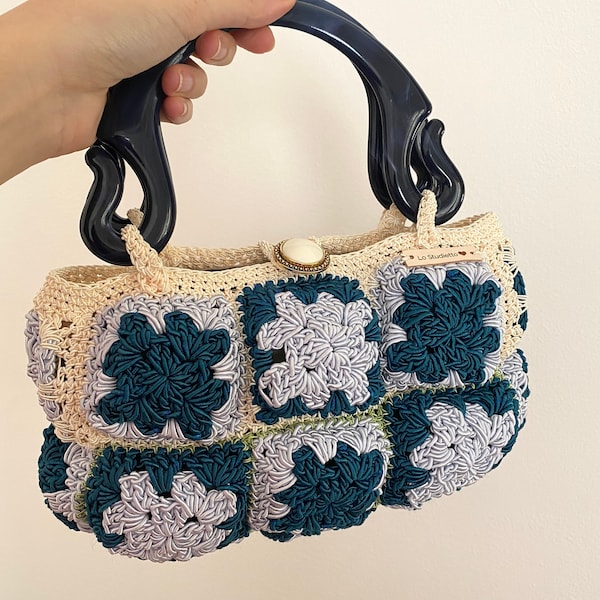 Sac rigide fabriqué avec un cordon de crochet et doublé d’un bouton bijou