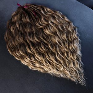 K&ouml;nnte beinhalten: Eine lange, wellige, braune und blonde Ombre-Haarverl&auml;ngerung mit einem burgunderfarbenen Band, das oben gebunden ist.