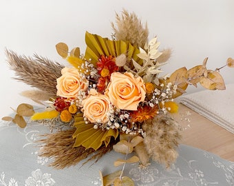 Bridal boho bouquet made of dried and preserved natural flower in orange pastel tones, bouquet with  eternal rose, pampas and palm
