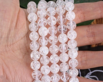 Può includere: Una collana di perle di quarzo trasparente con una texture a bolle o screpolata. Le perle sono rotonde e hanno un diametro di circa 8 mm.